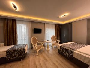 ein Hotelzimmer mit 2 Betten, einem Tisch und Stühlen in der Unterkunft Grand Wonne Hotel in Ankara
