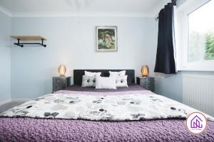 a bedroom with a large bed with a purple blanket at Luxury House, Swimming Pool, Hot Tub, Sauna in Cardiff