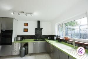 a kitchen with a stove top oven next to a window at Luxury House, Swimming Pool, Hot Tub, Sauna in Cardiff