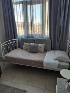 a bed sitting in a room with windows at Attalos luxury flat Psyrri square in Athens