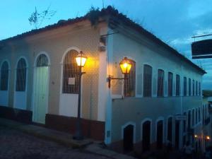 Biały budynek z lampką uliczną obok niego w obiekcie Pousada Catarina Mina w mieście São Luís