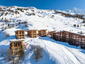 a resort in the snow with snow covered mountains at Résidence Arc - Chalets 114 in Arc 1800
