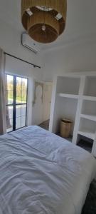 a bedroom with a large white bed with a chandelier at Villa BALI KECH in Marrakech +118 photos