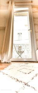 une fenêtre ouverte avec un rideau et un tapis dans l'établissement Le créateur - Cœur de ville, à Montpellier