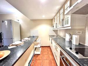 a large kitchen with black counter tops and white appliances at Casa Chus, cerca de la playa in Los Pocillos