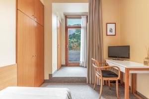 una camera d'albergo con scrivania e finestra di Albergo Sorriso a Boario Terme