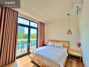a bedroom with a bed and a large window at HANZ Sofia Hotel Grand World in Phu Quoc