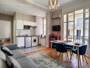 a living room with a couch and a table with chairs at Nestor&Jeeves - LILAS BUFFA - Central - Close sea - Top Floor in Nice