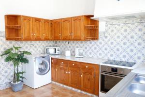 cocina con armarios de madera y lavadora en *Private Outdoor Area* 300m-Beach, Swing/No Stairs, en São Martinho do Porto