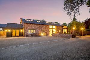 a brick house with a driveway in front of it at Skyfall in Prestbury