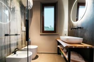 baño con lavabo, aseo y 2 espejos en Mistral Apartments, en Puntone di Scarlino
