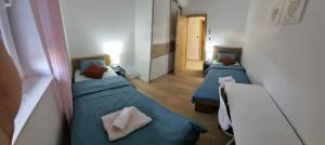 two beds in a room with blue sheets and pillows at Skitnica Prestige in Koprivnica