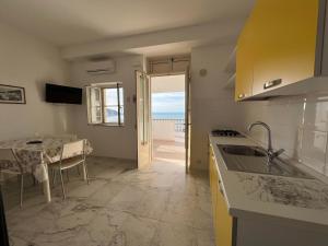 a kitchen with a table and a view of the ocean at Residence Tramonto in Peschici