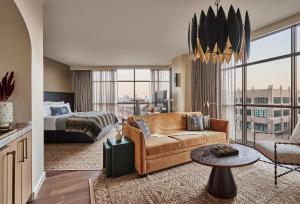 a living room with a couch and a bed at Bowie House, Auberge Collection in Fort Worth +37 photos