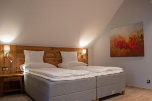 a bedroom with two beds and a painting on the wall at Resort CATTALEYA in Čeladná