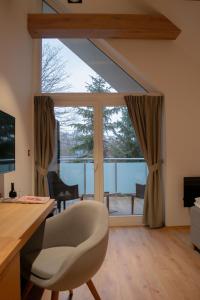 a living room with a desk and a large window at Resort CATTALEYA in Čeladná