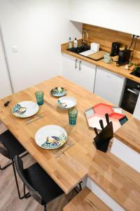 une cuisine avec une table en bois et des plaques de cuisson. dans l'établissement Le platanier - Centre ville, à Montpellier