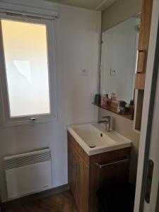 baño con lavabo y ventana en mobil home 441 en Pont-Aven