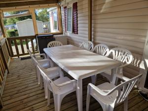 Biały stół i krzesła na ganku w obiekcie mobil home 441 w mieście Pont-Aven