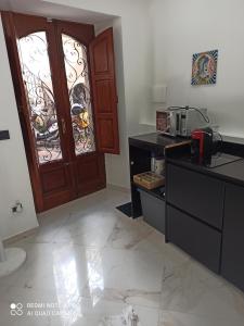 uma cozinha com uma porta e um balcão com um micro-ondas em MEDUSA house em Taormina