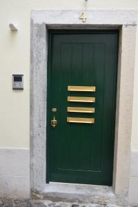 eine grüne Tür in einem Gebäude mit der Nummer vier in der Unterkunft Acolhedor Apartamento Em Alfama in Lissabon