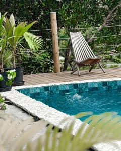 een houten terras met een stoel naast een zwembad bij JMJ Sugar in Rivière-Pilote
