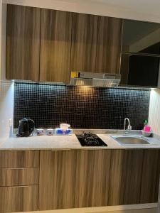 a kitchen with a sink and a counter top at Skylounge Balikpapan by Wika Realty in Sepinggang-besar