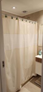 cortina de ducha blanca en el baño con lavamanos en Quequen - Casa Las Olas en Quequén