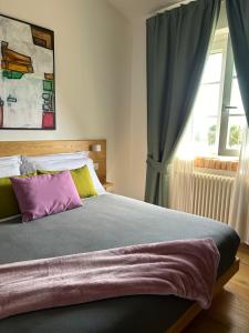 a bedroom with a bed with a purple pillow and a window at Casale Appia in Latina