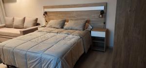 1 dormitorio con 1 cama grande y 1 silla en Quequen - Casa Las Olas en Quequén