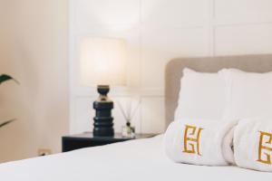 ein weißes Bett mit weißen Kissen und einer Lampe in der Unterkunft VIDA by ELEGANT - Brand New in Kairo