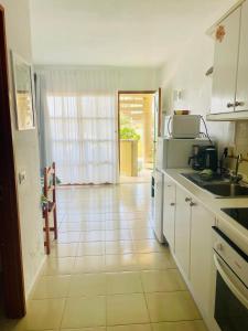 a kitchen with white cabinets and a tile floor at Sunlight apartment in Costa de Antigua in Costa de Antigua