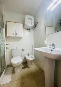 a white bathroom with a toilet and a sink at Sunlight apartment in Costa de Antigua in Costa de Antigua