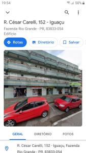 due auto parcheggiate in un parcheggio di fronte a un edificio di Espaço Verona - Quarto duplo 2 camas de solteiro a Fazenda Rio Grande