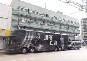 un autobus nero parcheggiato di fronte a un edificio di Espaço Verona - Quarto duplo 2 camas de solteiro a Fazenda Rio Grande