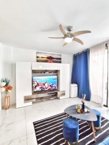 a living room with a tv and a table at Sunshine Escape with ocean view in Adeje