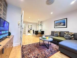 a living room with a couch and a tv at Stunning Houses with FREE PARKING in Little Venice with Canal view in London