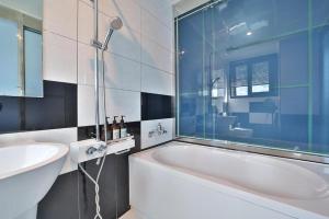 a bathroom with a white tub and a sink at Hermes Hotel in Busan +25 photos