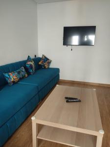 a living room with a blue couch and a coffee table at Appartement en m'diq centre ville près de la plage in M'diq