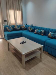 a blue couch with a coffee table in a living room at Appartement en m'diq centre ville près de la plage in M'diq