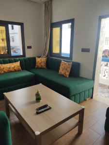 un soggiorno con un divano verde e un tavolino da caffè di Appartement en m'diq centre ville près de la plage a M'diq