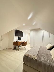 a bedroom with a bed and a desk with a computer at Villa de luxe JO 2024 in Saint-Brice-sous-Forêt