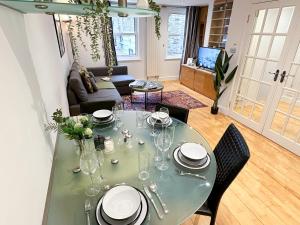 uma sala de estar com uma mesa com pratos e copos em Stunning Houses with FREE PARKING in Little Venice with Canal view em Londres