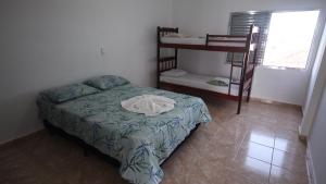a bedroom with a bed and a bunk bed with a ladder at Resort Saúde Premium in Peruíbe