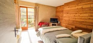 1 dormitorio con 1 cama, TV y ventana en Les Clarines Perceneige - Chambre d'Hôtes Vue Sur Montagne, en Saint-Jacques-en-Valgodemard