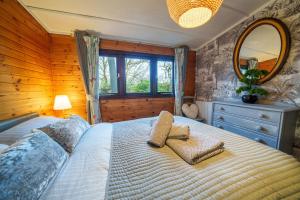 a bedroom with a large bed and a mirror at Dock Tarn Lodge in Ambleside +19 photos