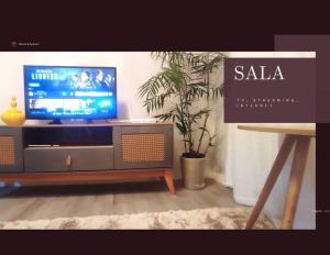 sala de estar con TV en un soporte en Eletric Car Flat, en Teófilo Otoni