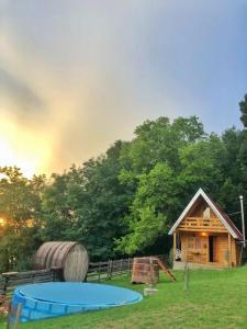 Cabaña de madera con mesa y barril en Taćina i Dokina kolibica en Arandjelovac