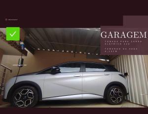 biały samochód stoi w garażu w obiekcie Eletric Car Flat w mieście Teófilo Otoni