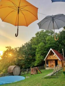 um par de guarda-chuvas no ar com uma cabine em Taćina i Dokina kolibica em Arandjelovac